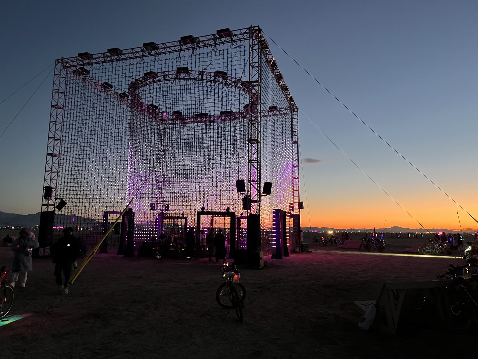 The cube at dawn against an orange horizon