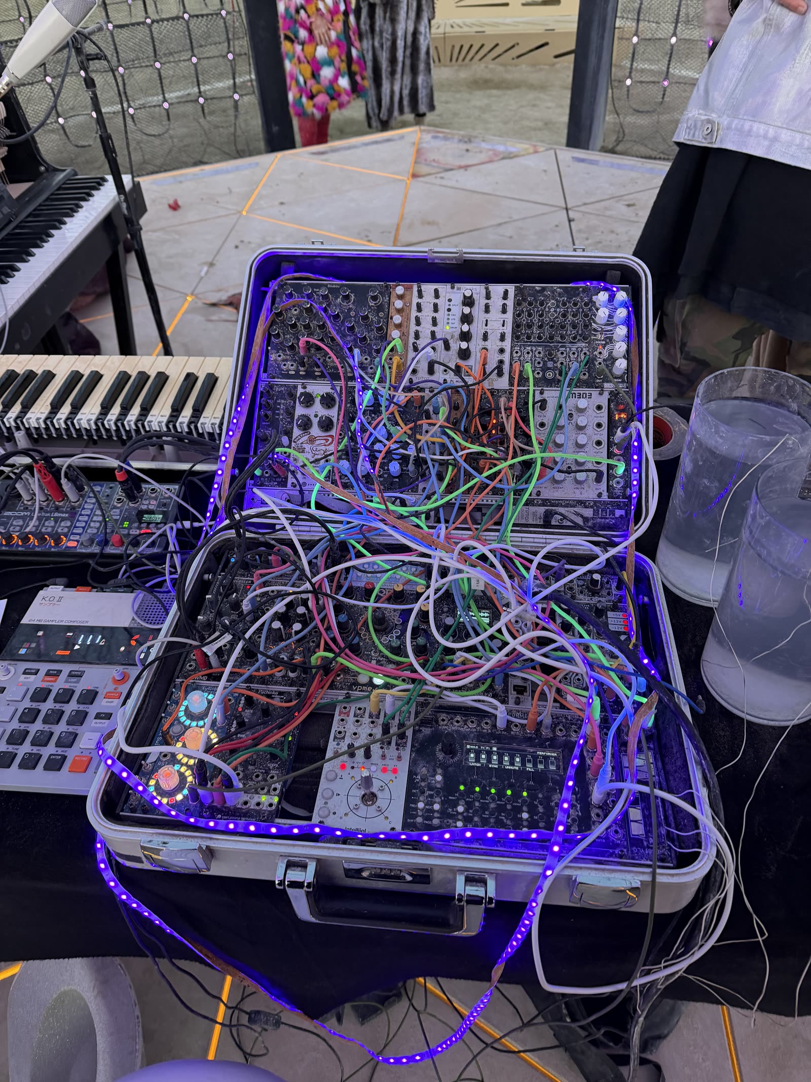 An open case of modular synth modules and patch cables